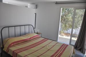 a bedroom with a bed and a large window at Villa Salem Maison d'architecte toute équipée & piscine in Arkou