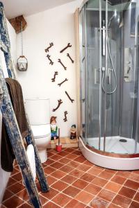 a bathroom with a shower with bones on the wall at Le Moulin de Chamambard in Saint-Denis-lès-Bourg