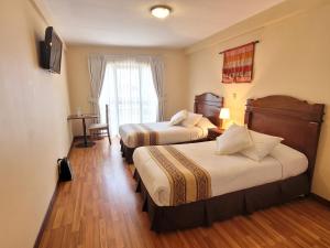 a hotel room with two beds and a window at Hotel Monte Carlo in La Paz