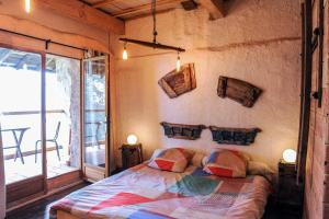 a bedroom with a bed and a large window at Le Moulin de Chamambard in Saint-Denis-lès-Bourg