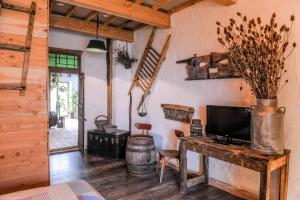 uma sala de estar com uma mesa com uma televisão e uma parede de madeira em Le Moulin de Chamambard em Saint-Denis-lès-Bourg