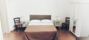 a bedroom with a large bed with two chairs at Accogliente Dimora in Putignano