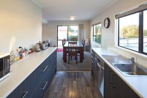 a kitchen with blue cabinets and a sink and a table at Bedrock - Lake Tekapo in Lake Tekapo