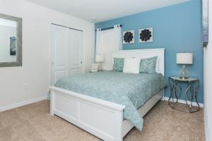 1 dormitorio con 1 cama blanca y paredes azules en Luxury 7BR 6BA Home Private Pool and BBQ only13min to Disney 4788 sqft, en Kissimmee