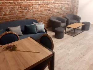 a living room with a blue couch and a table at Loft Apartament ULA in Elblag