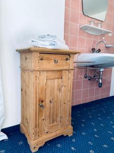 a wooden cabinet in a bathroom with a sink at Königin Serles - großzügig, gemütlich & nachhaltig in Fulpmes