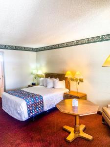 ein Hotelzimmer mit einem Bett und einem Tisch in der Unterkunft Econo Lodge Inn & Suites in Winnemucca