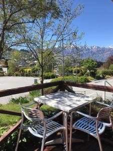 a table and chairs on a porch with a view of the mountains at Hampshire Holiday Parks - Queenstown Lakeview in Queenstown