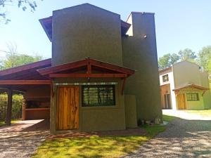 una casa con una puerta de madera en el césped en Papa Ruku, en Villa Ciudad Parque