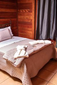 a bedroom with two beds with towels on them at Chalés Paradiso in Nova Friburgo