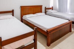 a trio of beds in a room at Recanto do Village in Porto Seguro +29 photos