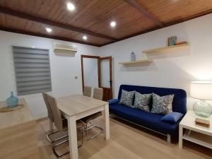 a living room with a blue couch and a table at Spacious Apartment in Armilla