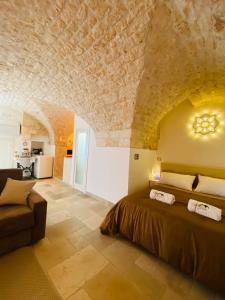 1 dormitorio con 1 cama grande y techo de piedra en Dimora Le Volte Ostuni, en Ostuni