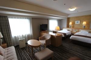 a hotel room with two beds and a television at Smile Hotel Tokushima in Tokushima +37 photos