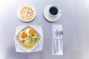 einen Tisch mit einem Teller Eiern und einer Tasse Kaffee in der Unterkunft Ayenda Zhena in Cúcuta