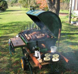 a bbq grill with food on it in a park at Pilmaiquen in Riachuelo