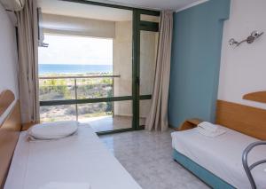 ein Schlafzimmer mit zwei Betten und einem großen Fenster in der Unterkunft Amfibia Beach Complex in Sonnenstrand + 71 Fotos