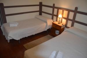 a bedroom with two beds and a lamp on a table at Casa Rural Bigotes in Arlanzón