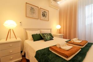 una camera da letto con un letto e due asciugamani di Janela Mar Garden a Lagoa
