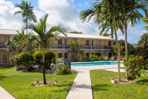 a resort with a swimming pool and palm trees at Orange Hill Beach Inn in Nassau