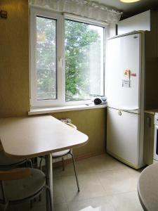 クリンにあるChaykovsky Apartment KLINのキッチン(テーブル、冷蔵庫付)、窓が備わります。