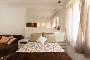 Un dormitorio pequeño con una cama y un sofá. en Aparts -Hotel Cavalinho Branco, en Águas de Lindóia 71 fotos más