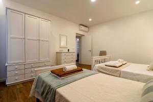 a bedroom with two twin beds and a dresser at Janela Mar Garden in Lagoa