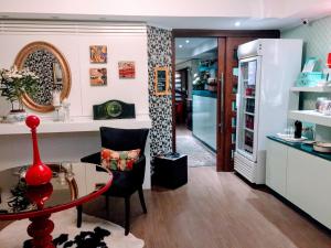 a living room with a table and a refrigerator at Porto Retrô Residence in Porto Alegre