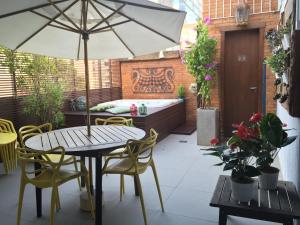 a patio with a table and chairs and an umbrella at Porto Retrô Residence in Porto Alegre