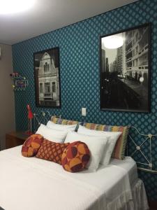 uma cama num quarto com uma parede azul em Porto Retrô Residence em Porto Alegre