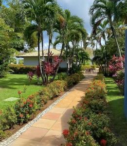 a walkway in front of a house with palm trees at Summer Flat in Guarajuba