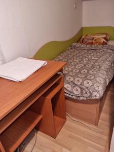 1 dormitorio con cama y escritorio de madera en Lester Apartments, en Skopje