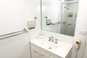 a bathroom with a sink and a mirror at Summit Motel in Townsville