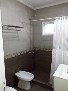 een badkamer met een douche, een toilet en een wastafel bij Punto Termal - Depto 8 in Federación