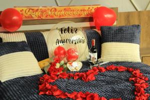 a bed with a table with red flowers and balloons at Glamping Caliza La Calera in La Calera