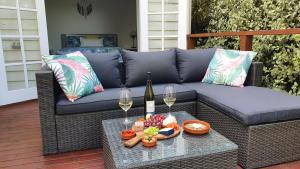 um sofá com dois copos de vinho e uma mesa em A Coonawarra Experience em Penola