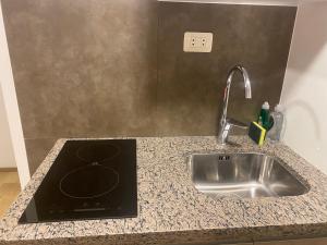 a kitchen counter with a sink and a stove at Smart studio in Cochabamba