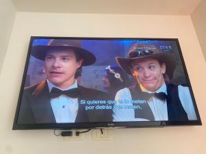 uma televisão de ecrã plano com dois homens na parede em Smart studio em Cochabamba