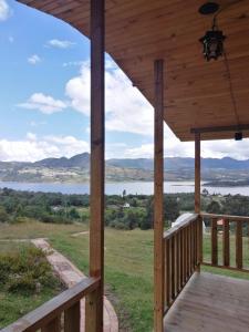 a wooden porch with a view of a lake at Cabaña San Martin in Guatavita