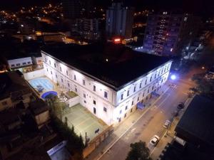 a large white building with a tennis court at night at Palace Hotel de Caxambu in Caxambu