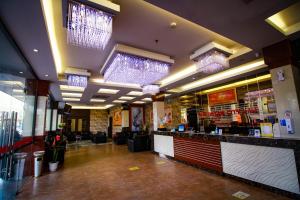 a restaurant with a bar with lights on the ceiling at Batam City Hotel in Nagoya