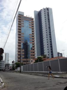 una mujer caminando por la calle con un paraguas en Apart hotel- FLAT no melhor do Manaíra 401 en João Pessoa