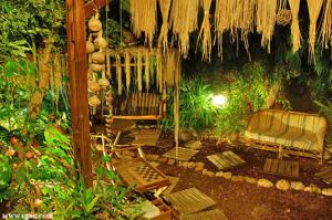 a patio with chairs and a thatch roof at צימר בגליל אביב בבקתה in Galilee