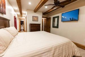 a bedroom with a large bed and a flat screen tv at Villa Cortina 130 in Vail Village in Vail