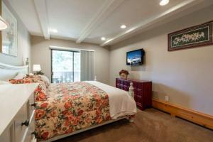 um quarto com uma cama com colcha floral e uma janela em Condo with Outdoor Heated Pool and Free WiFi em Vail