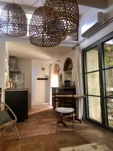 a dining room with a table and some chandeliers at La petite maison in Lourmarin