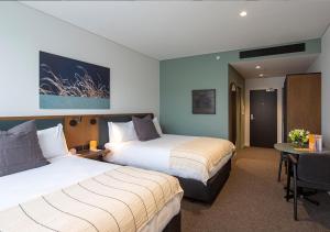 a hotel room with two beds and a table at Sudima Queenstown Five Mile in Queenstown