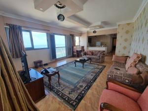 Panoramic Sea View ZAMZM Flat miami FAMILY ONLY شقة فندقية زمزم بانورما بشاطئ ميامي - الاسكندرية صف اول مباشر علي بحر - عائلات فقط في الإسكندرية: غرفة معيشة مع أريكة وتلفزيون
