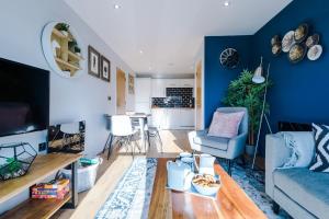 a living room with a blue accent wall at Style and Comfort with Private FREE Parking, Sheffield in Sheffield