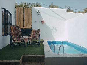a patio with two chairs and a swimming pool at La Casita Verde Valle in La Fuente Grande